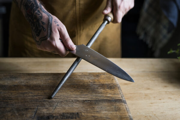 Professional chef sharpening knife in the kitchen Professional chef sharpening knife in the kitchen