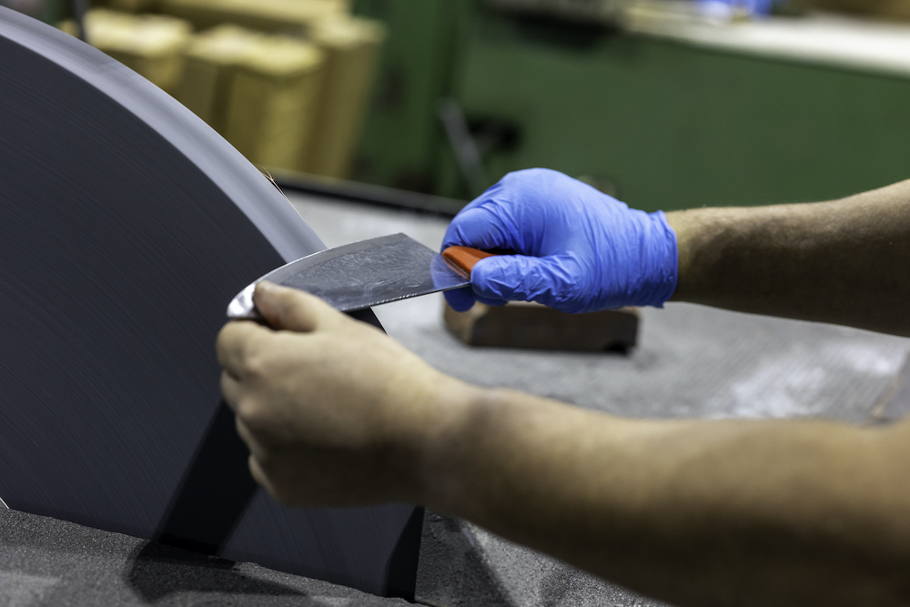 gloved hand sharpening a knife