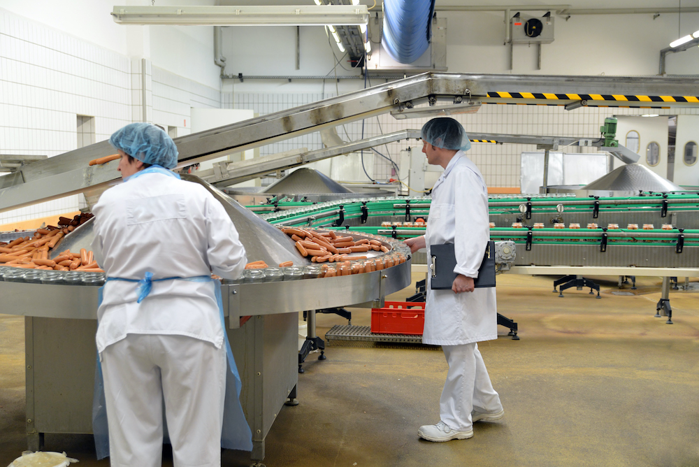 two workers in a meat processing facility